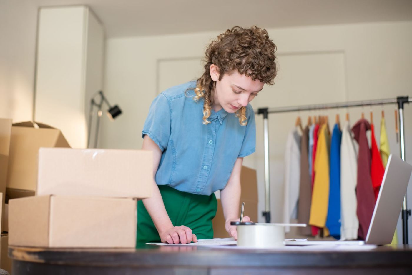 Dona de uma pequena loja organizando pedidos com o notebook aberto